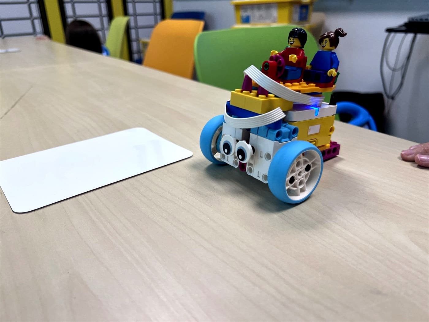 Pojazd zbudowany z klocków LEGO® SPIKE Essential z dwiema figurkami i świecącym hubem