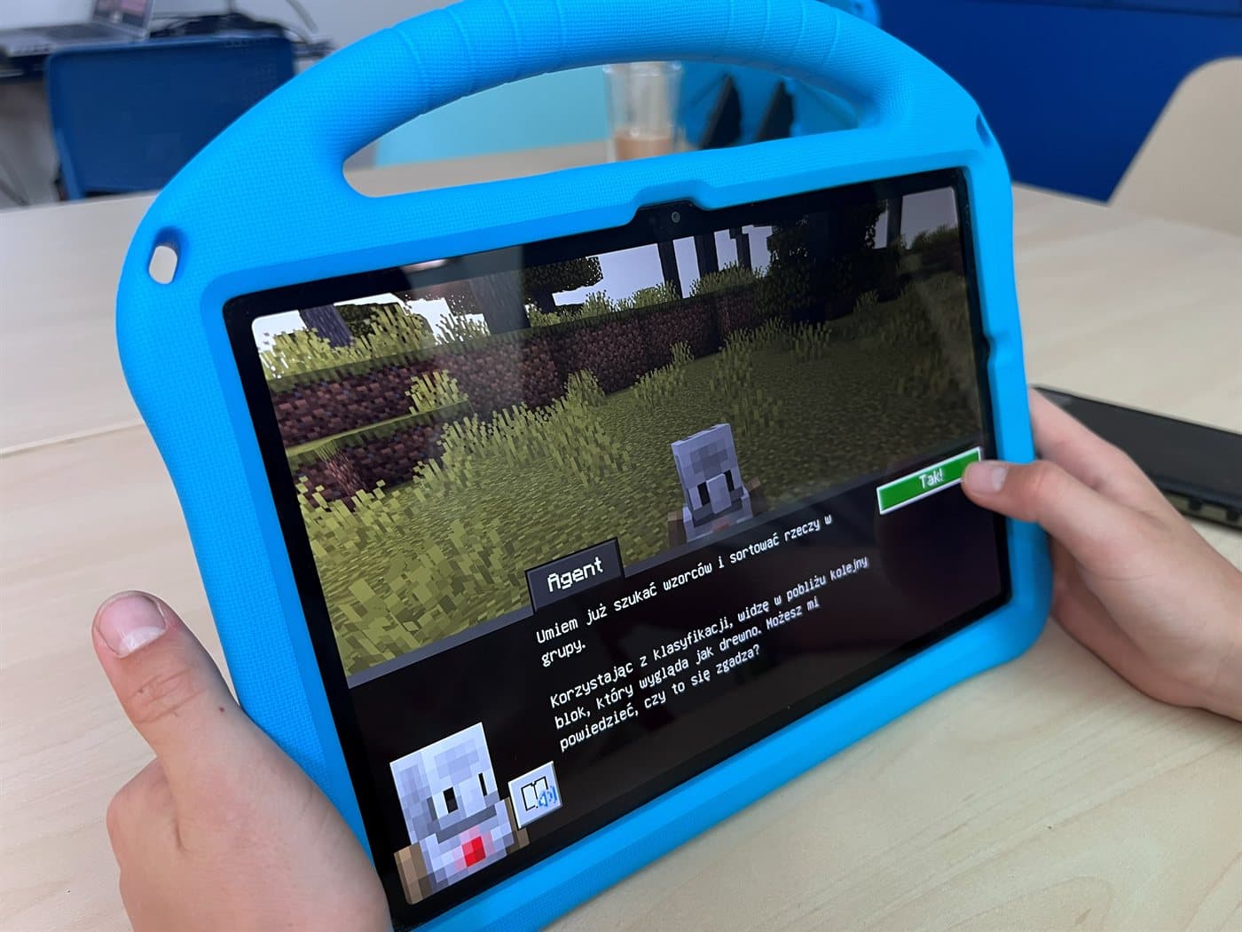 Tablet z Minecraft Education - Agent AI podaje dziecku zadanie do wykonania